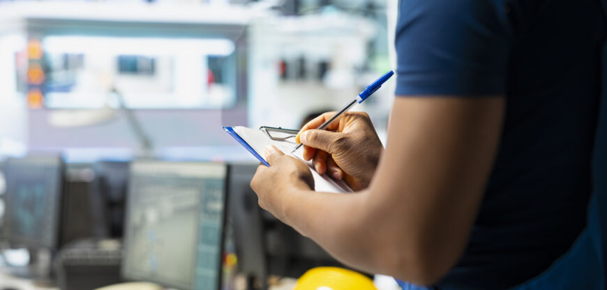 solar panel manufacturing plant researcher taking notes on files,